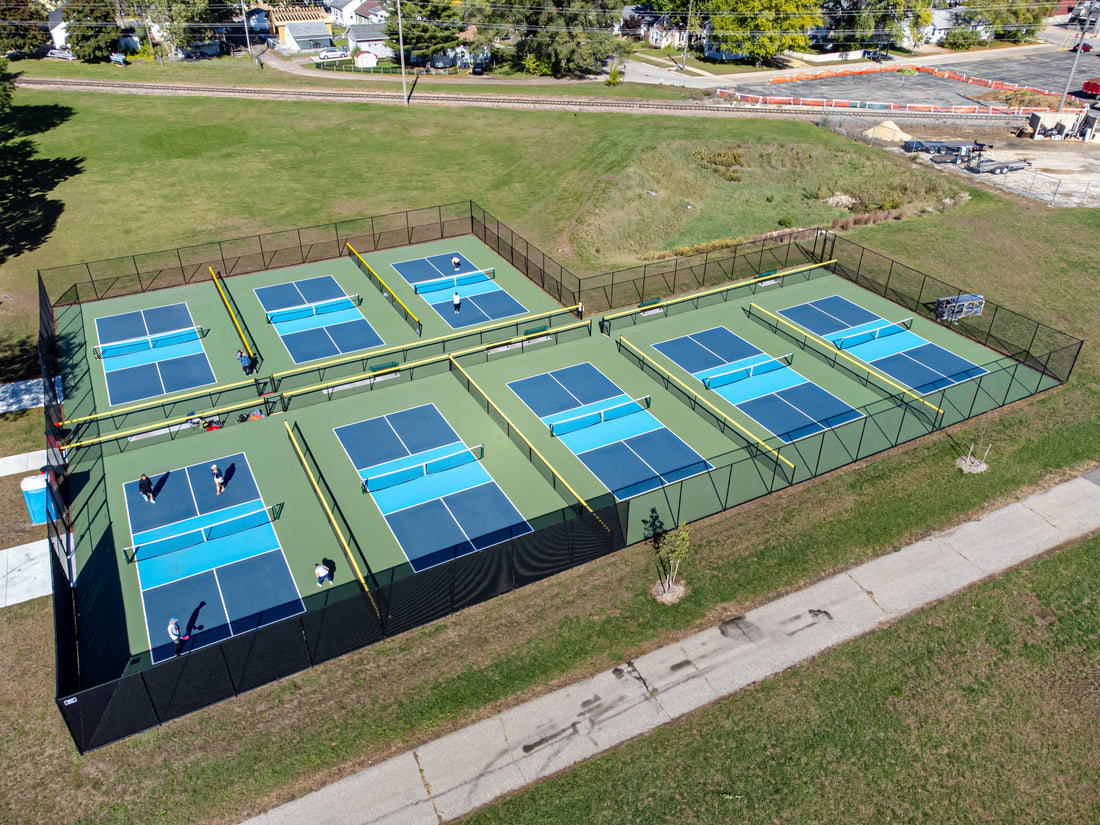 Aerial view of a row of fenced outdoor pickleball courts