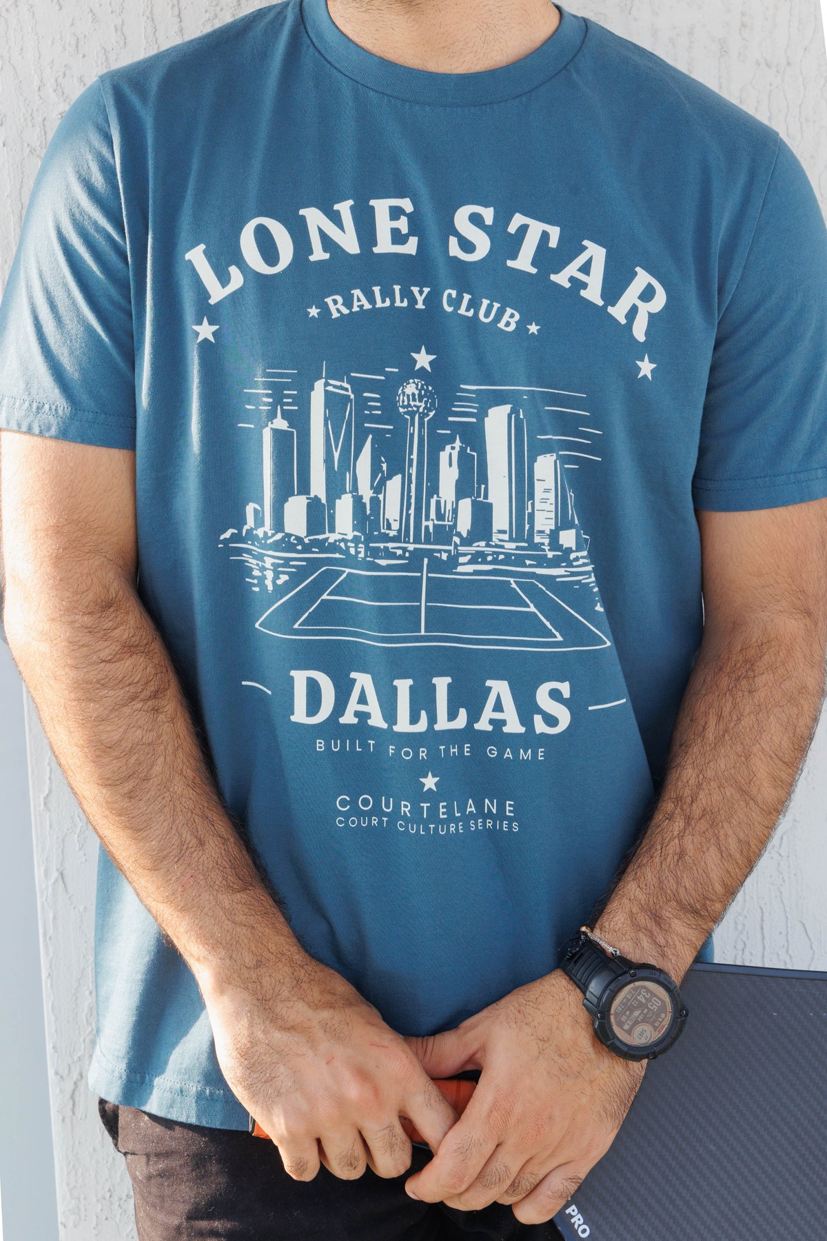 Close up of the Lone Star Rally Club Dallas skyline print on the blue Courtelane men's tee
