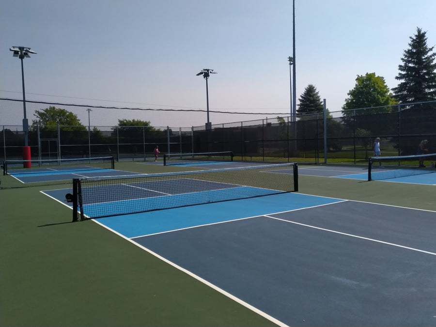 Empty outdoor pickleball courts in a park on a clear morning